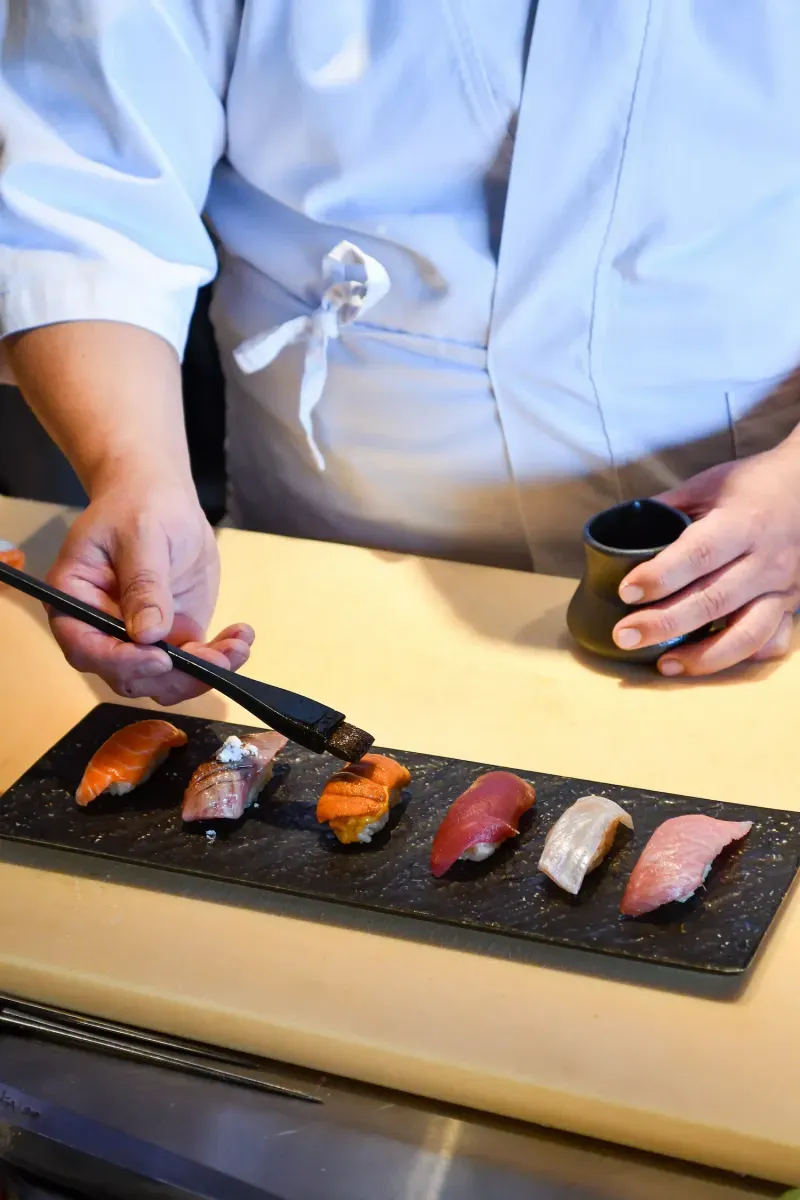 Chef finishing sushi at The Naisho Room counter